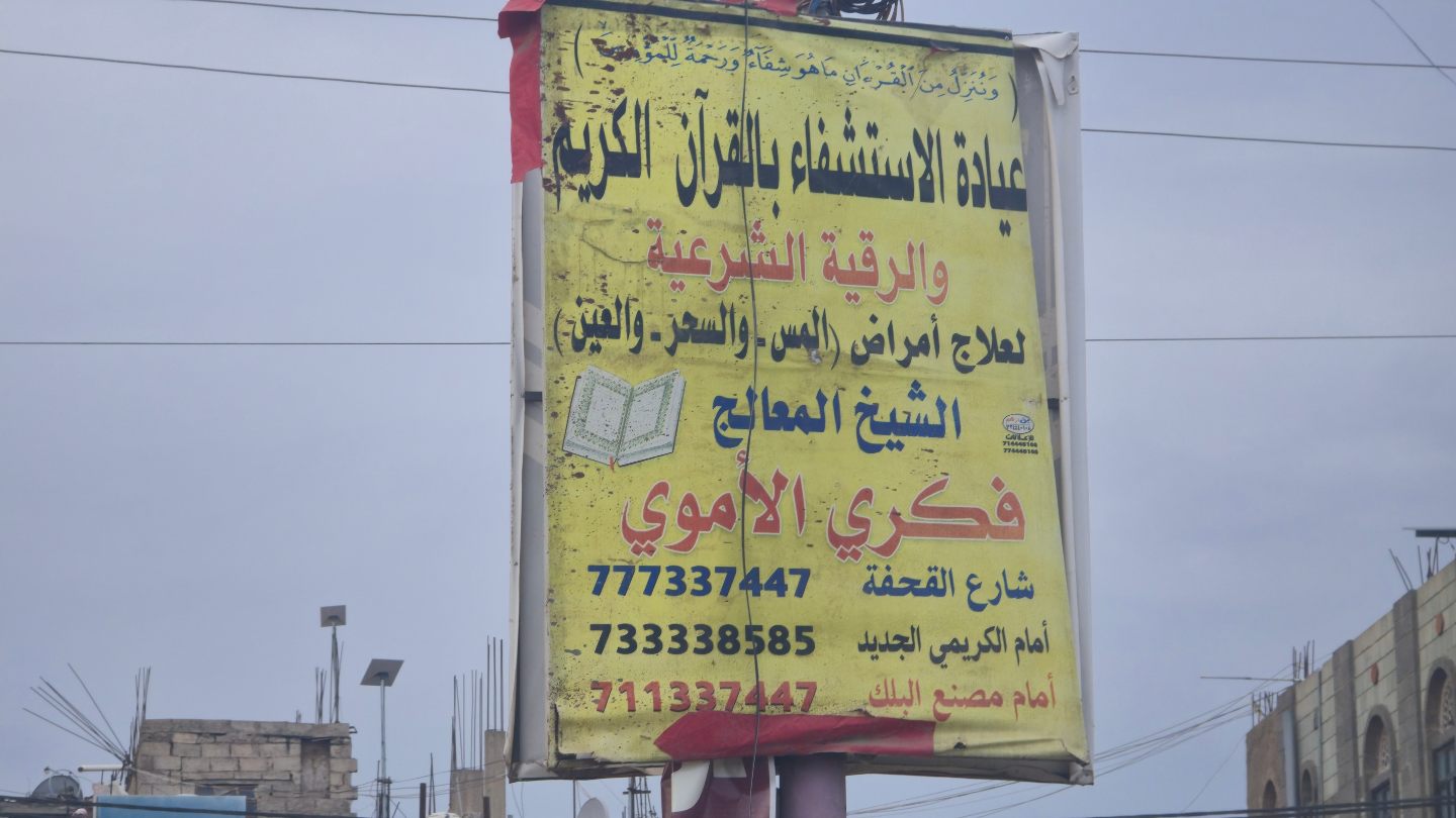 A street sign advertises Quranic healing for the evil eye, magic and jinn possession in Taiz, Yemen (Nasser Al Sakkaf)